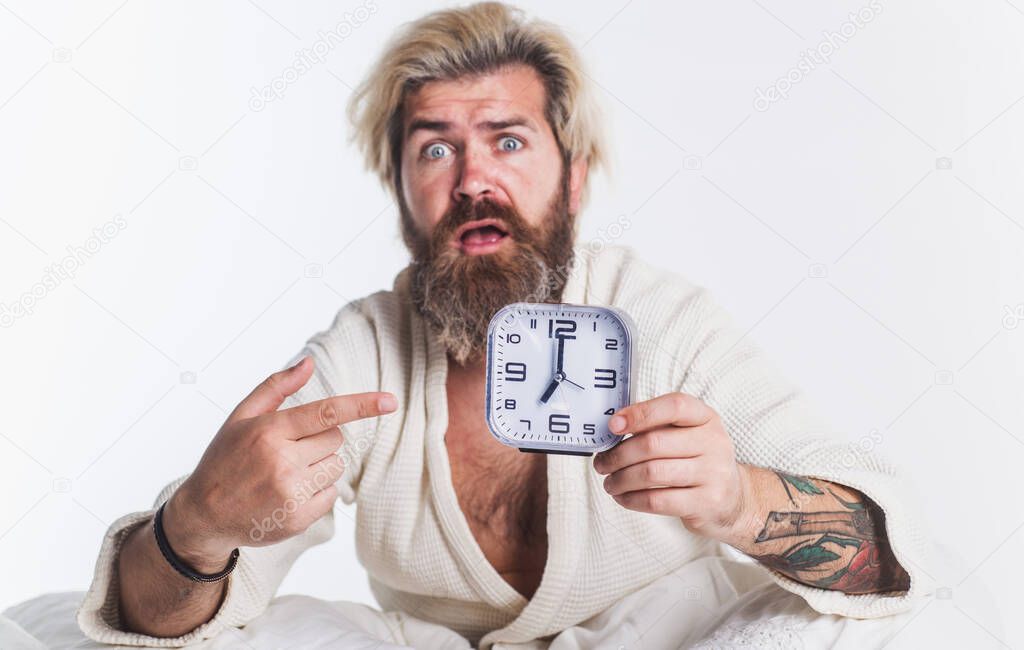 Oversleeping. Shocked bearded man in bed with alarm clock. Late For Work, Bad Morning, Tardiness Concept.