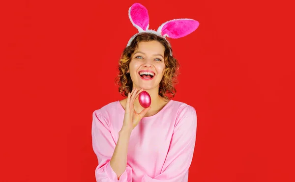 Пасхальные праздники. Охота на яйца. Счастливая женщина в кроличьих ушах с розовым яйцом. Девочка-кролик. Весеннее время. — стоковое фото