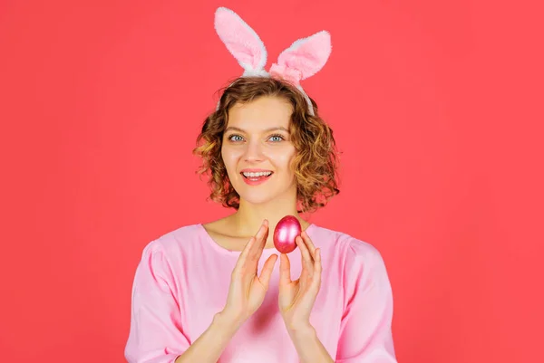 Счастливой Пасхи. Улыбающаяся девушка с розовым яйцом. Весенние каникулы Женщина в кроличьих ушах. Охота на яйца. — стоковое фото