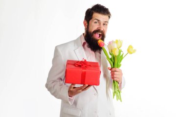 Doğum günü hediyesi ve buket lalesi olan mutlu bir adam. Çiçekli ve hediyeli sakallı adam..