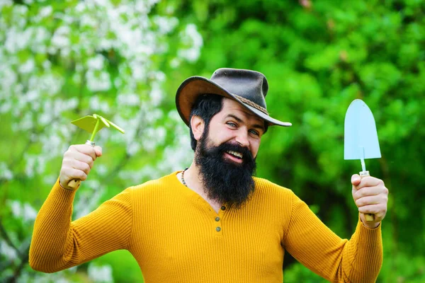Bearded man with gardening tools. Gardener work in garden. Spring. Smiling male prepare to planting.