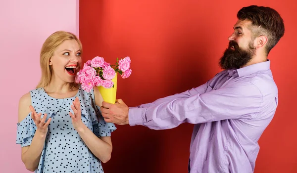 Een paar verliefd op een boeket bloemen. Een knappe man met een baard geeft rozen aan een vrouw. Liefde, relatie. — Stockfoto