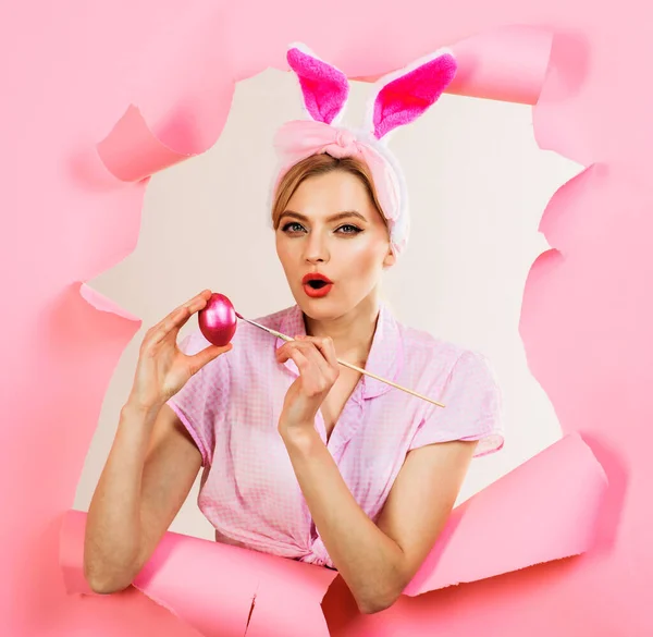 부활절 날. 달걀에 그림을 그리는 여자가 놀랬어요. 페인트 붓 과 분홍 달걀을 가진 토끼 귀에 있는 감각적 인 여자. — 스톡 사진