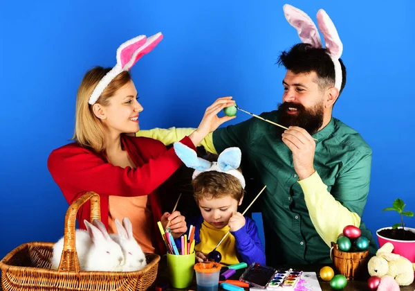 イースターの日にウサギの家族。母、父と息子の卵を描く。ウサギの耳の幸せな家族. — ストック写真