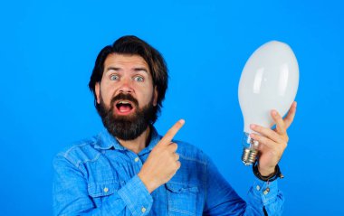 Yaratıcı yeni fikir. Ampullü şaşırmış bir adam. Beyin fırtınası, ilham. Enerji ve elektrik.