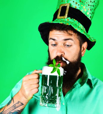 Patricks Günü. Yeşil bira içen cüce şapkalı sakallı adam. 17 Mart. Biranın içinde bir yılan. Yakın çekim..