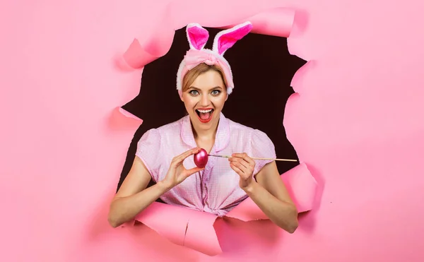 행복 한 어른. 토끼 귀에 웃는 여자 애가 계란을 그리고 있어. 분홍색 달걀 과 붓을 가진 토끼 여성. — 스톡 사진