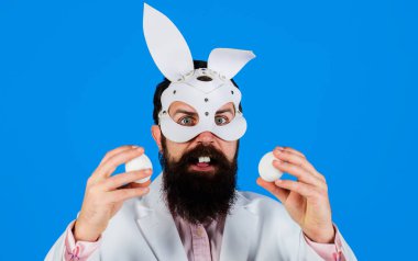 Paskalya Günü. İki beyaz yumurtası olan tavşan maskeli sakallı adam şaşırdı. Tavşan adam. Yumurta avı.