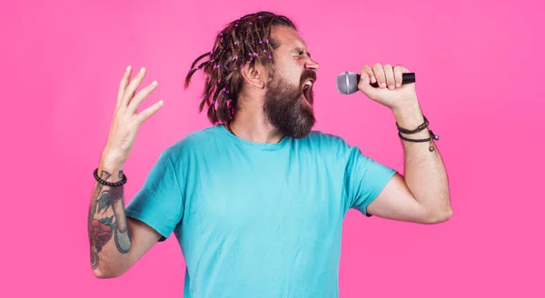 Homem barbudo a cantar com microfone. Bonitão de t-shirt azul Canta em karaoke. Conceito musical. — Fotografia de Stock