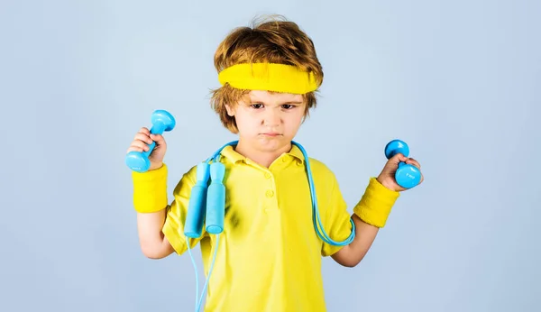Child sportsman. Kid boy with skipping rope lifting dumbbells. Children fitness. Healthy childhood. — Stock Fotó