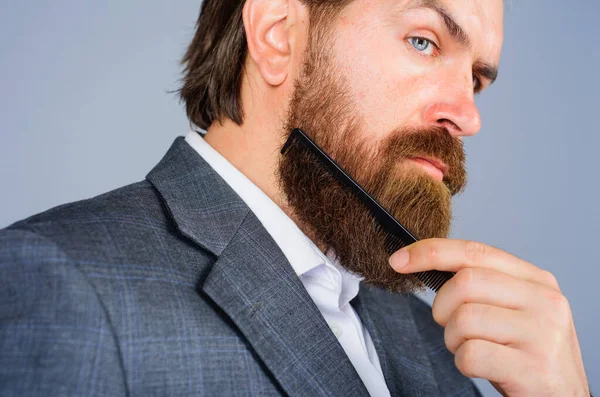 Barbershop reclame. Een man met baard en kam. Professionele baardzorg. Een kapper. Salon voor mannen. — Stockfoto