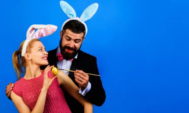 Family celebrate Easter day. Bunny couple in rabbit ears painting egg. Happy holidays. Season sale.