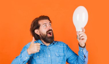 - İyi fikir. Ampullü mutlu adam baş parmağını gösteriyor. Sakallı erkek, elinde büyük bir lamba var..