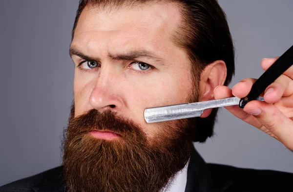 Kapperszaak. Portret van een man met baard en scheermes. Professionele baardzorg. Kapper gereedschap. Salon voor mannen. — Stockfoto