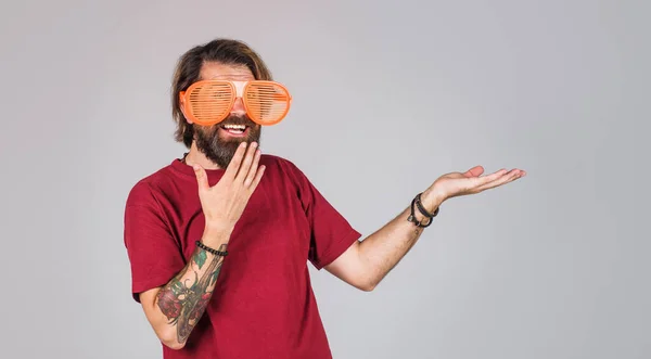 Homem surpreso em óculos grandes engraçados apresentando produto segurar algo na palma da mão. Temporada Venda, desconto. — Fotografia de Stock