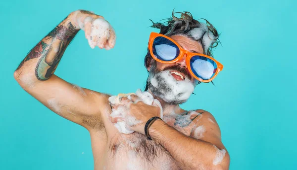 にこにこする男はシャワーで保湿ジェルで体を洗う 眼鏡をかけた髭の男 朝のルーチン — ストック写真