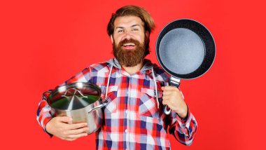 Kızartmalı ve tencereli bir adam. Kızartma tavası ve tenceresi olan bir şef. Yemek pişirmek. Mutfak eşyaları. Mutfak aletleri