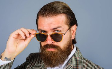 Güneş gözlüklü yakışıklı sakallı iş adamı. Erkek modası. Vogue. Göz giysisi reklamı. Ciddi adam.
