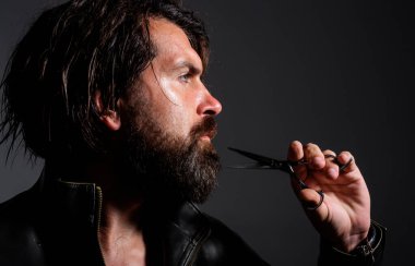 Berber aletli yakışıklı sakallı adam. Makas ver. Sakal stili ve kesim. Berber dükkanında erkek tıraşı