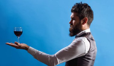 Elinde kırmızı şarapla sakallı bir adam. Sommelier alkol tadıyor. Restorandaki garson.
