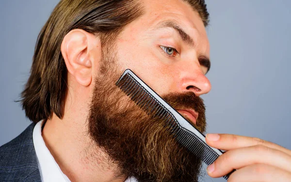 Barbershop. Bearded man with barber comb. Professional beard care. Hairdresser. Closeup portrait