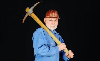 Kazmalı, üniformalı sakallı adam. Sert şapkalı, kazma kafalı bir erkek müteahhit. Madencilik aygıtı