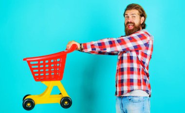 Süpermarket. Boş alışveriş arabası ya da tramvayı olan mutlu sakallı bir adam. Marketten. Seri satın alma