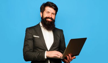 Gülümseyen iş adamı dizüstü bilgisayarla ya da not defteriyle çalışır. Ofis, iş, teknoloji, internet