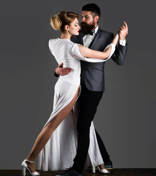 Beautiful couple in love dancing passionate dance. Professional dancers in elegant suit and dress