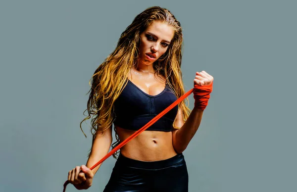 Sport woman preparing for fight. Fighter girl in sports top with red bandages fists. Female boxer