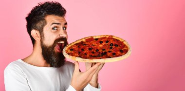 Lezzetli pizza yiyen aç bir adam. İtalyan yemeği. Sakallı adam pizzanın tadını çıkarıyor. Sağlıksız beslenme