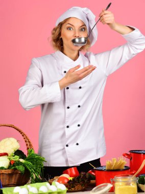 Female chef in white uniform with ladle spoon. Cooking and professional culinary. Food preparation