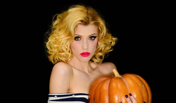 Sexy woman with pumpkin. Halloween holiday. Trick or treat. Serious blonde girl with jack-o-lantern
