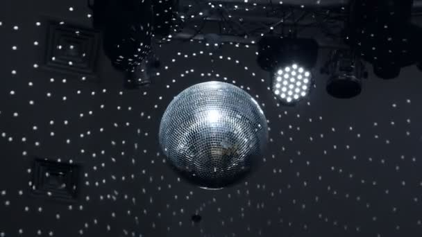 Sfera discoteca ruota sotto il soffitto in una discoteca, brilla e riflette la luce — Video Stock