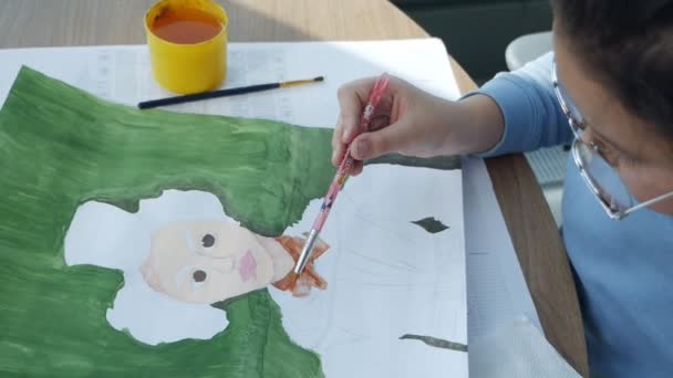 Barnet ritar en bild med en pensel. Kreativt barn lär sig att rita på papper.Barn i ritning.Slow motion — Stockvideo