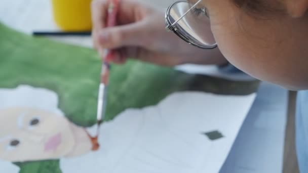 Παιδικό χέρι με ένα πινέλο σχεδιάζει μια εικόνα σε χαρτί — Αρχείο Βίντεο