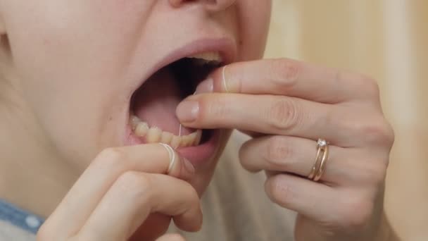 Hilo dental. Dientes de Chitska con hilo dental primer plano, observancia de la higiene bucal — Vídeos de Stock