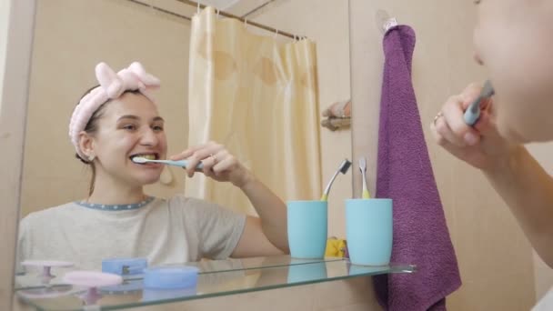 Kobieta myje zęby przed lustrem. — Wideo stockowe