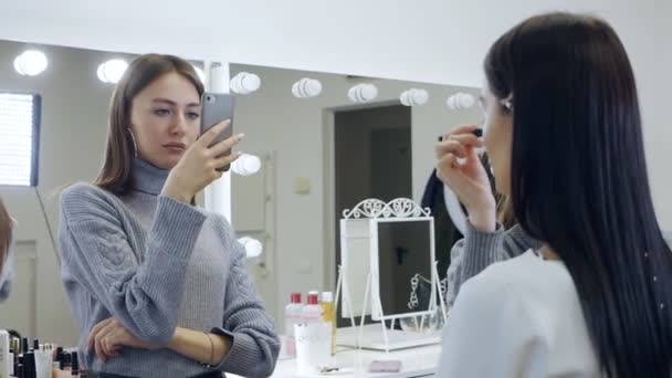 Video to your smartphone for a beauty blog. Makeup artist and blogger made a video tutorial on makeup. Beginner make-up artist records a professional make-up artists lesson on the phone — Stock Video