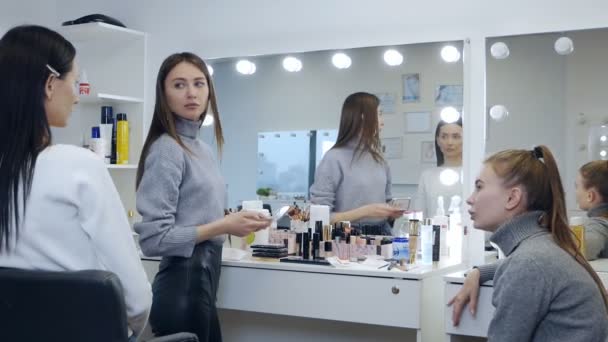 Mladá žena profesionální make-up umělec výuka její mladý student, aby se stal make-up umělec v mistrovské třídě v salonu krásy — Stock video