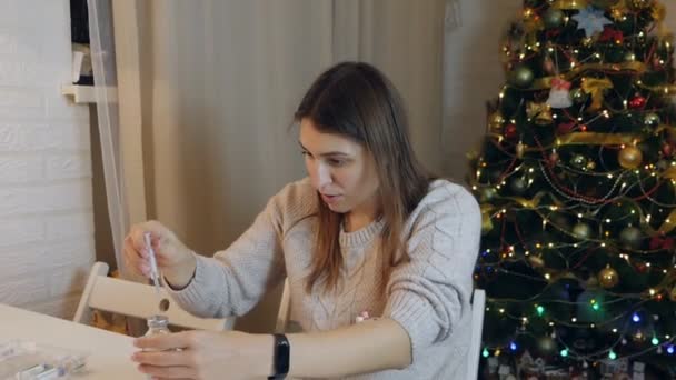 Young woman holding ampoule with medicines, inserting needle into rubber cap and filling syringe at home — Stock Video