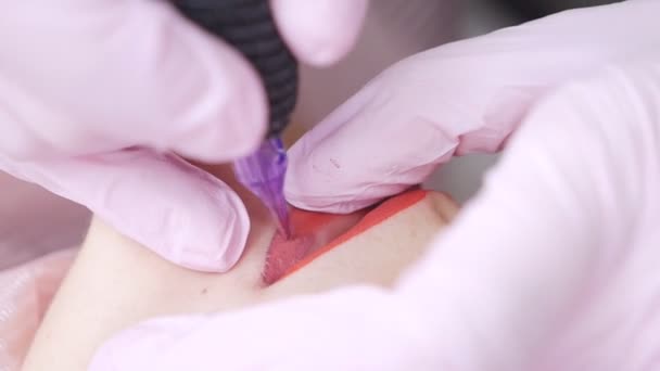 Татуировка губ на микролезвии специальным красным пигментом, который корректирует цвет губ в косметологической клинике — стоковое видео