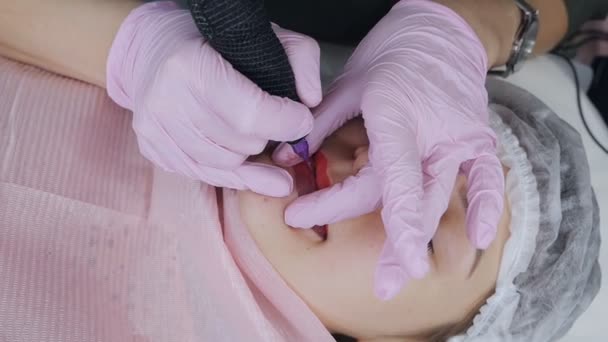Tatouage à lèvres Microblading avec un pigment colorant spécial qui corrige la couleur des lèvres dans la clinique de cosmétologie — Video