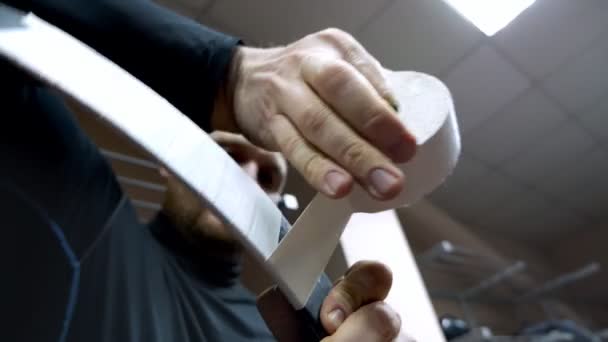 A hockey player glues the blade of his club in preparation for the game — Video Stock