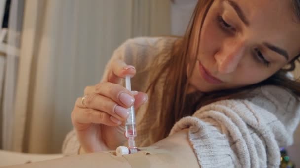 Young woman alone, at home injects medicine from a syringe into a vein — 비디오