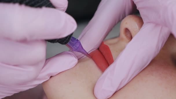 Procédure permanente de maquillage des lèvres avec application de maquillage pigmentaire sur les lèvres à l'aide d'une machine à tatouer close-up — Video