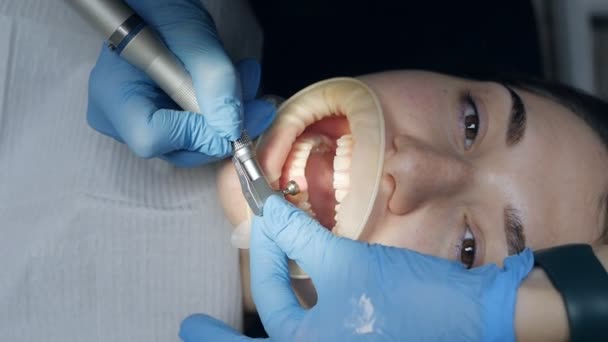 Patient mit Wangenrückzieher an. Professionelle Zahnreinigung, Patientin