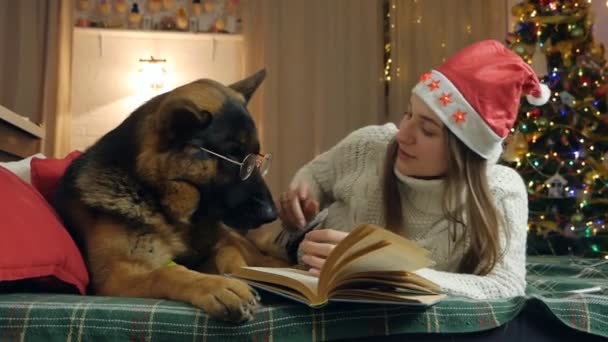 Καλά Χριστούγεννα διακοπές, χαλαρώστε διαβάζοντας ένα βιβλίο μυθιστορημάτων μαζί με την οικογένειά σας στο σπίτι.Χριστούγεννα ιδέες διακοπών έννοια — Αρχείο Βίντεο