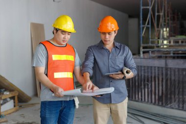 İnşaat mühendisi ve mimar inşaat alanında mavi baskı ile çalışma kavramı