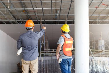 İnşaat mühendisi ve mimar inşaat alanında mavi baskı ile çalışma kavramı